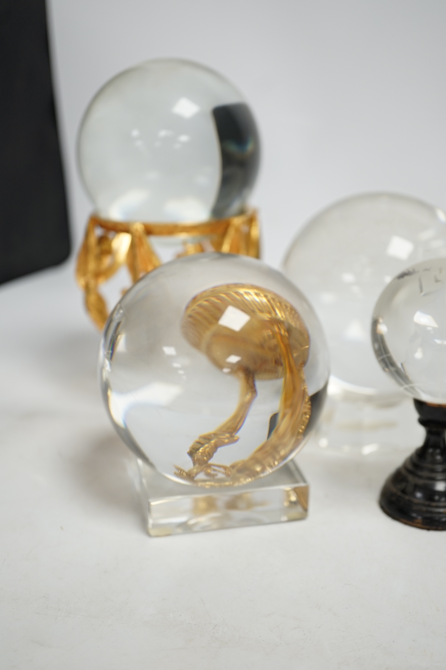 A group of six crystal balls on stands, largest 14cm across. Condition - fair